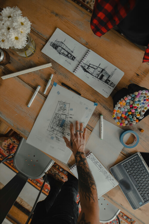 Photos d'un architecte en train de dessiner des plans de construction, ainsi que des crayons à dessin